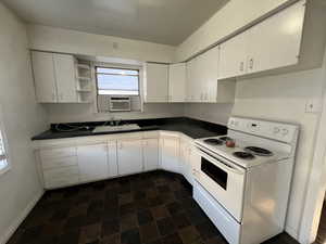 Kitchen with white range with electric stovetop, cooling unit, white cabinetry, and sink