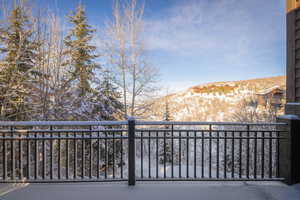 Snow covered back of property with a mountain view