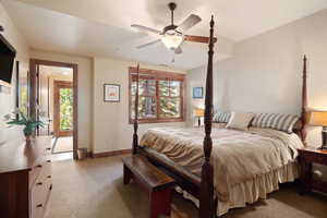 Bedroom with ceiling fan, light carpet, and multiple windows