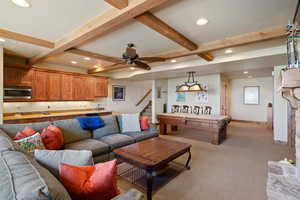 Living room with beam ceiling, light colored carpet, ceiling fan, and pool table