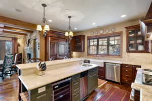 Kitchen with plenty of natural light, beverage cooler, stainless steel dishwasher, and a kitchen island