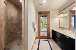 Bathroom with tile patterned floors, vanity, and walk in shower