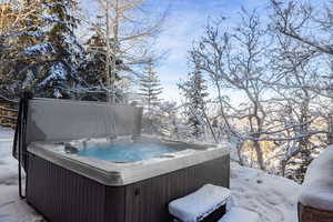 Snow covered deck with a hot tub