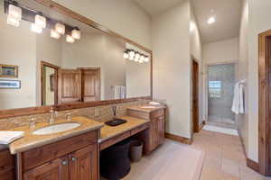 Bathroom with tasteful backsplash, vanity, and a tile shower