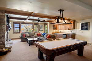 Game room with light carpet, sink, a stone fireplace, and billiards