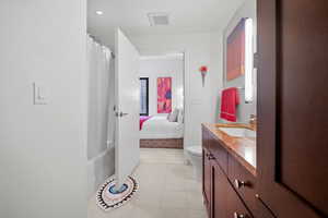 Full bathroom with tile patterned flooring, vanity, toilet, and shower / tub combo with curtain