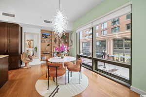 Dining space featuring built in shelves, light hardwood / wood-style flooring, and an inviting chandelier