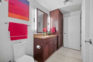 Bathroom with tile patterned floors, vanity, and toilet