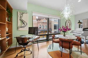 Dining area with light hardwood / wood-style flooring and a notable chandelier