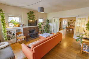 Living room featuring a brick fireplace, a textured ceiling, and light wood-type flooring