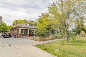 View of front of house with covered porch and a front lawn