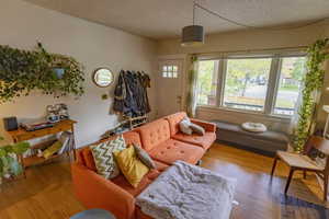 Living room featuring a textured ceiling and light hardwood / wood-style flooring