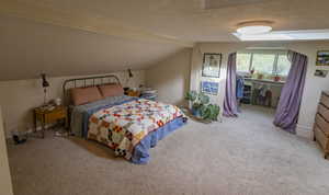 Carpeted bedroom featuring a textured ceiling and vaulted ceiling