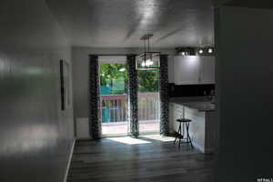 Dining space with dark hardwood / wood-style floors and a textured ceiling