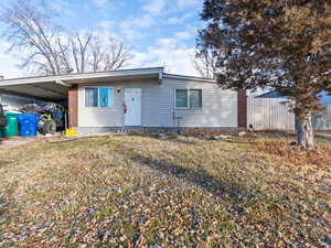 Single story home with a carport and a front lawn