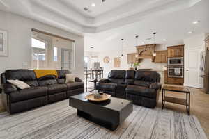 Living room with light tile patterned flooring and a raised ceiling