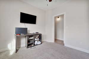 Home office featuring light carpet and ceiling fan