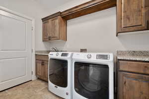 Washroom featuring cabinets, washer and dryer, and sink