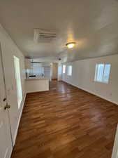 Unfurnished living room with hardwood / wood-style floors and a textured ceiling