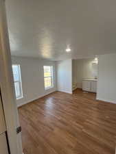 Empty room featuring light hardwood / wood-style flooring, a textured ceiling, and sink