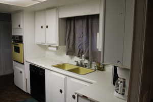 Kitchen featuring sink, white cabinets, and black appliances