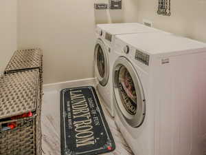 Clothes washing area featuring washing machine and dryer