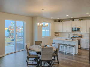 Dining space with a textured ceiling, dark hardwood / wood-style floors, and a notable chandelier