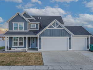 View of front of home featuring a garage, covered porch, and a front yard