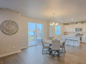 Dining area featuring a textured ceiling, light hardwood / wood-style flooring, a notable chandelier, and sink