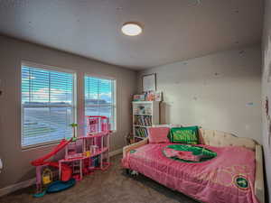 Carpeted bedroom with a textured ceiling