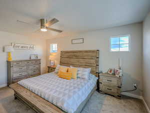 Carpeted bedroom with multiple windows, a textured ceiling, and ceiling fan