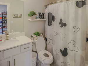 Bathroom featuring curtained shower, vanity, a textured ceiling, and toilet