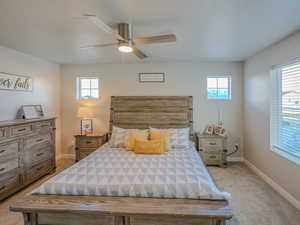 Carpeted bedroom with a textured ceiling and ceiling fan