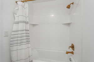 Bathroom featuring shower / bathtub combination with curtain