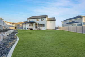 Back of house featuring a lawn, a patio area, and outdoor lounge area