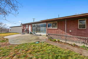 Rear view of house featuring a patio area and a yard