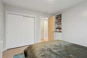 Bedroom with light hardwood / wood-style floors and a closet