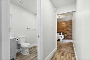 Bathroom with hardwood / wood-style floors, vanity, and toilet