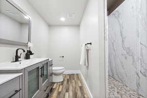 Bathroom with vanity, hardwood / wood-style flooring, toilet, and walk in shower