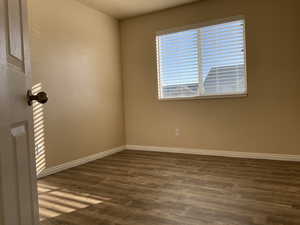 Unfurnished room featuring dark hardwood / wood-style flooring