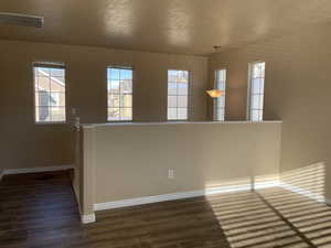 Empty room featuring dark hardwood / wood-style flooring