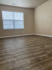 Empty room featuring dark hardwood / wood-style floors