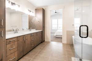 Bathroom featuring tile patterned floors, ceiling fan, vanity, and vaulted ceiling