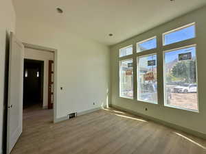 Spare room featuring light wood-style flooring and baseboards