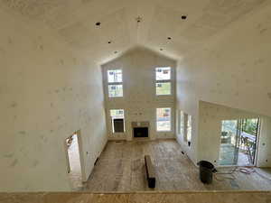 Unfurnished living room featuring high vaulted ceiling