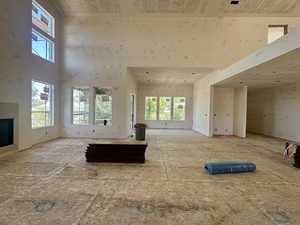 Unfurnished living room with a high ceiling and a fireplace