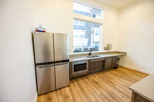 Kitchen with light wood-type flooring, stainless steel appliances, and sink