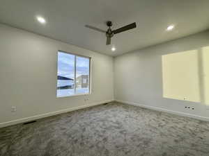 Carpeted spare room with ceiling fan