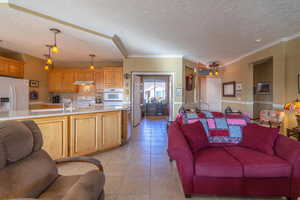 Tiled living room with a textured ceiling and ornamental molding