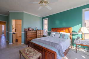 Bedroom featuring a textured ceiling, ceiling fan, ornamental molding, and light carpet